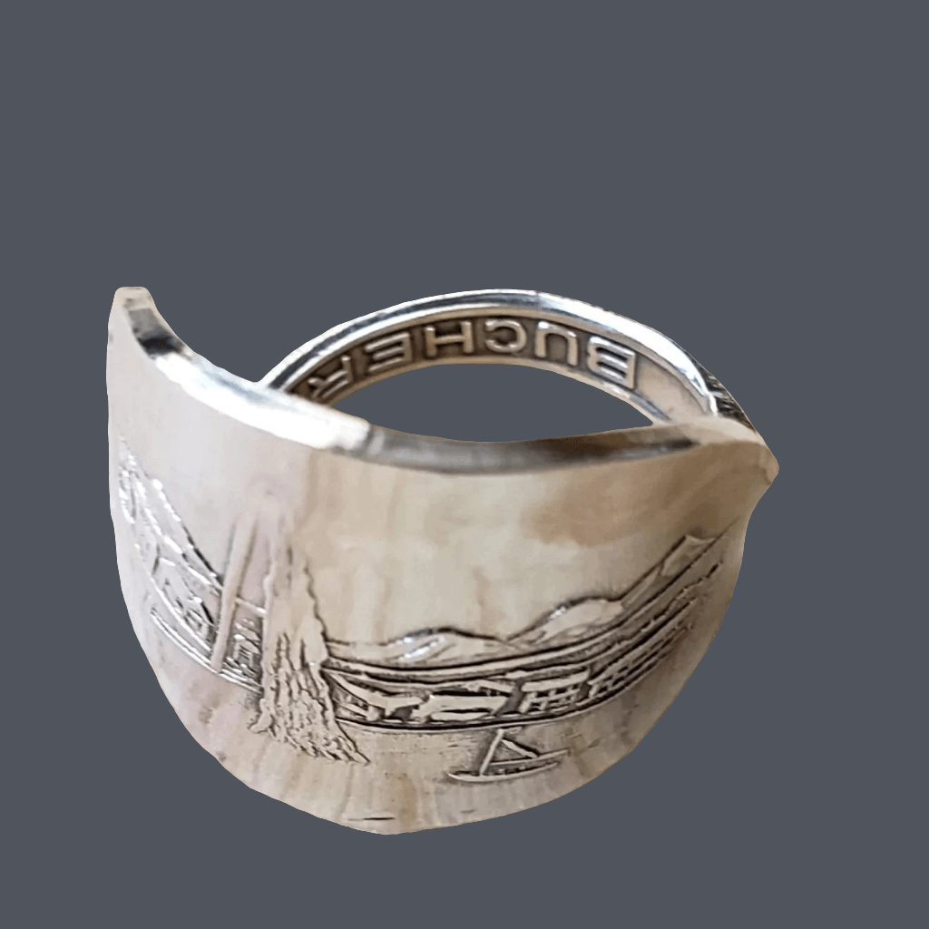 Silver ring with engraved design on a gray background