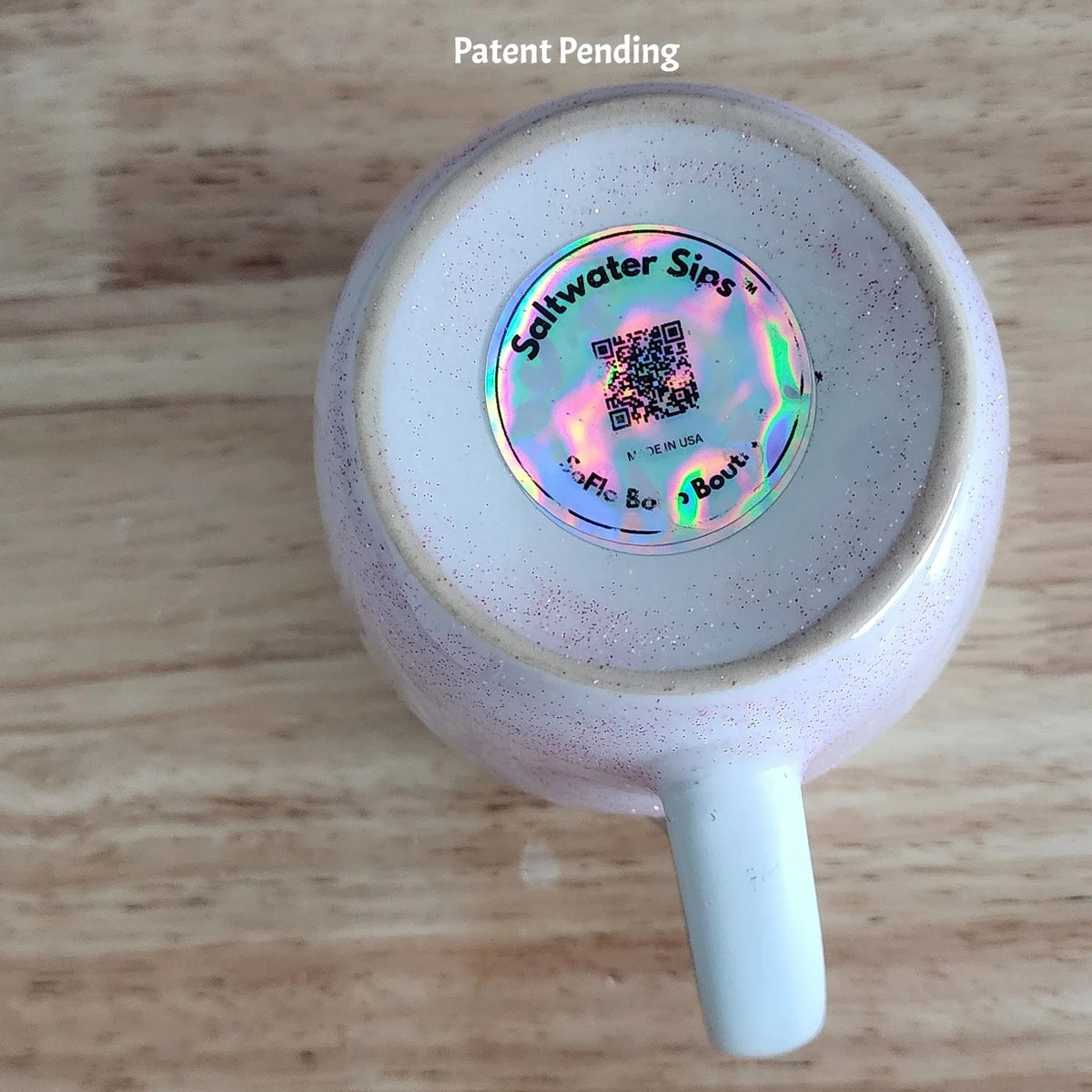 Bottom view of handmade ceramic coffee mug on wood surface