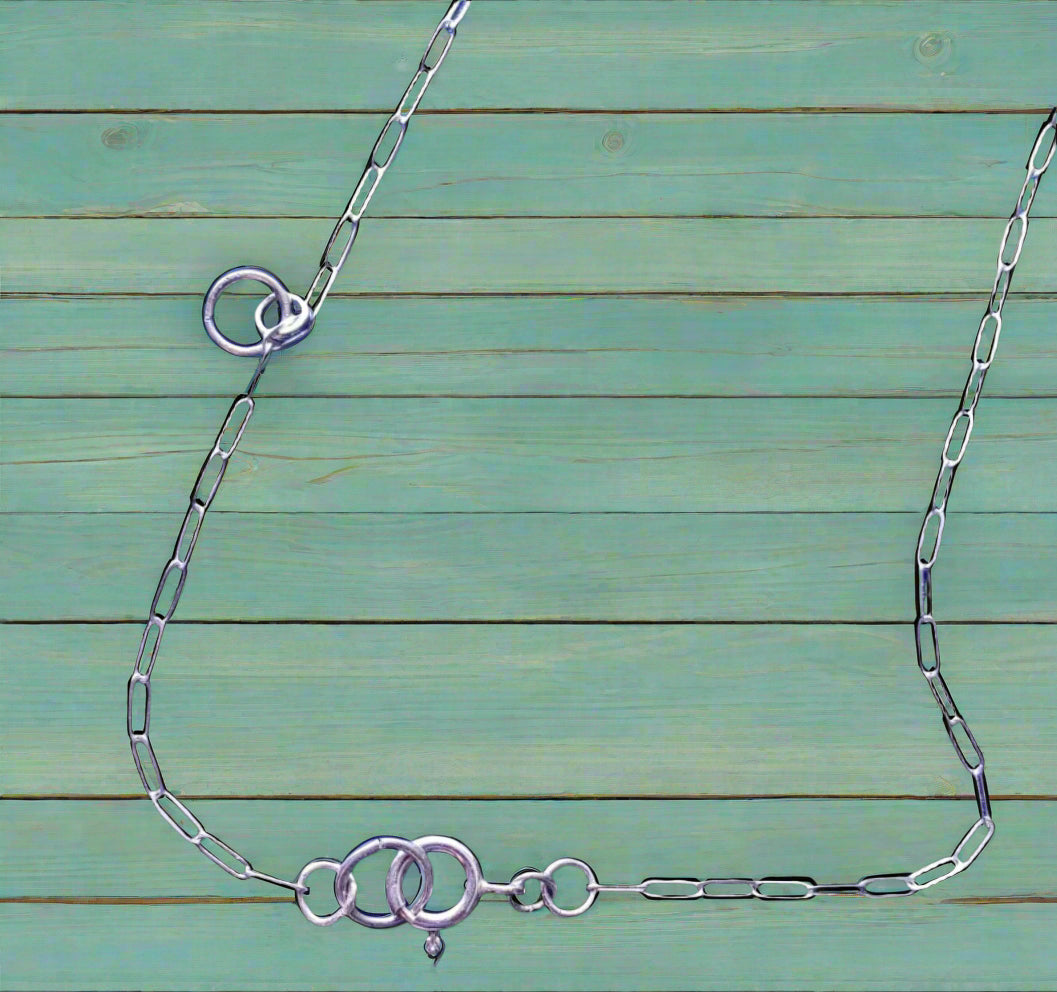 Silver chain necklace on a wooden surface