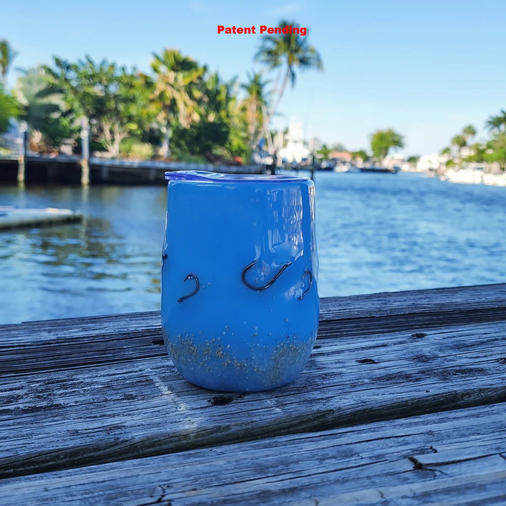Blue Tide Hook & Tumble™ coastal tumbler outdoors with palm trees and intracoastal waterway background