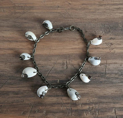Cowrie shell anklet bracelet flat lay on wood background with alternating clear and brown glass beads