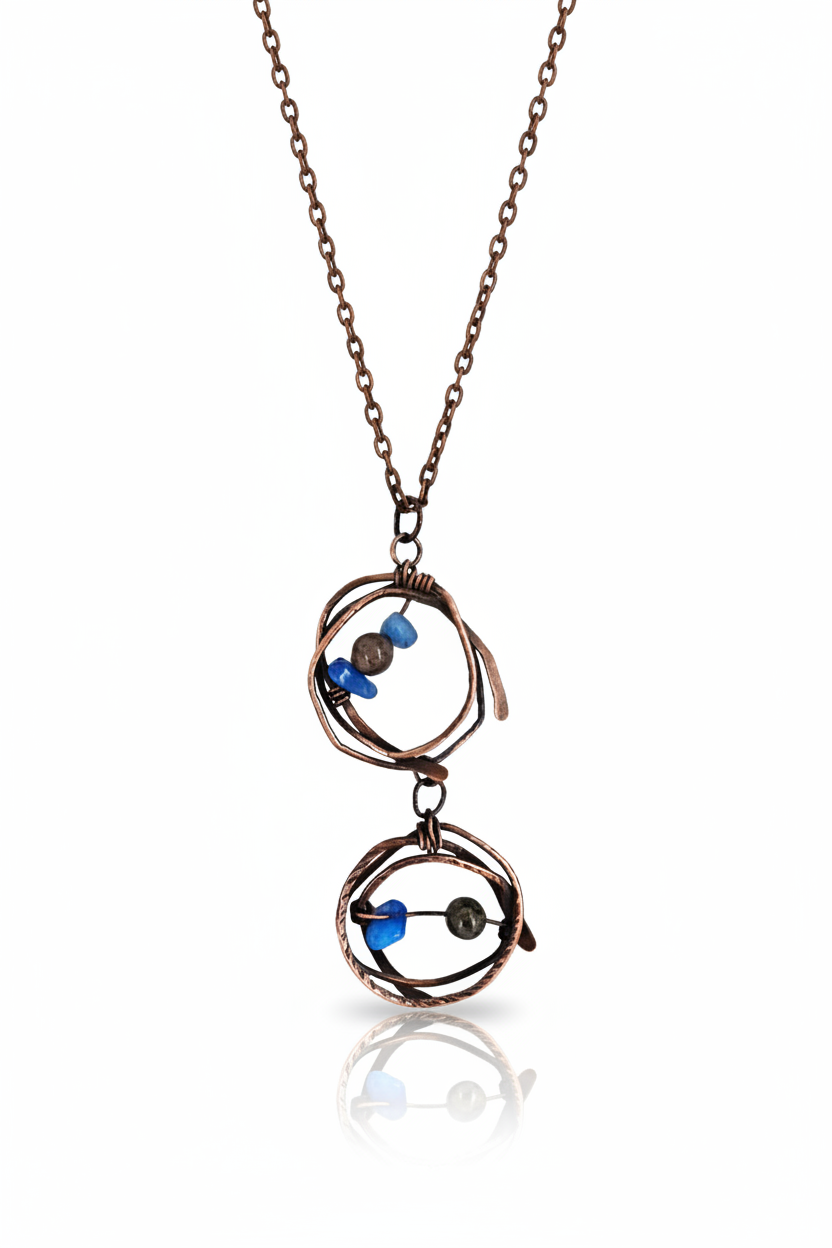 Handmade copper wire-wrapped pendant necklace with brown jasper and blue abalorios beads, resting on linen fabric