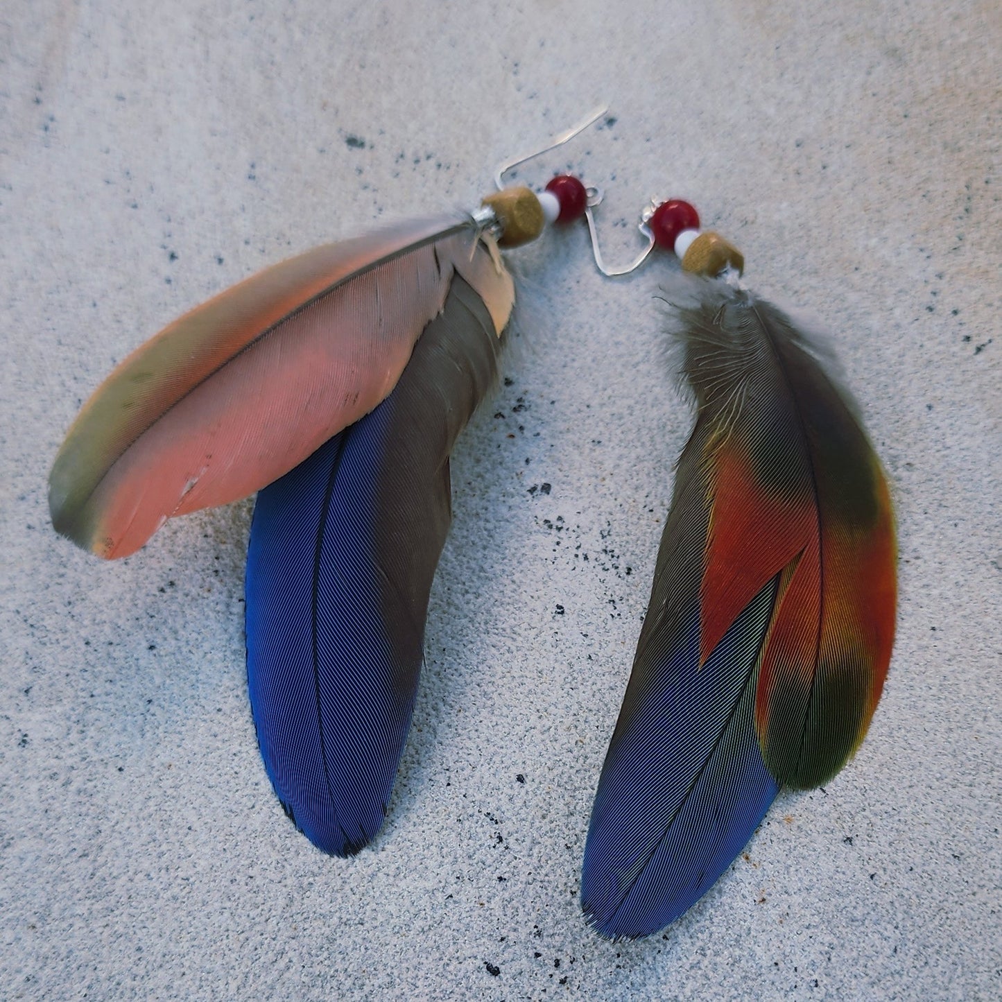 Handmade blue green feather earrings with white howlite, wood, and coral-colored beads, long coastal dangle earrings