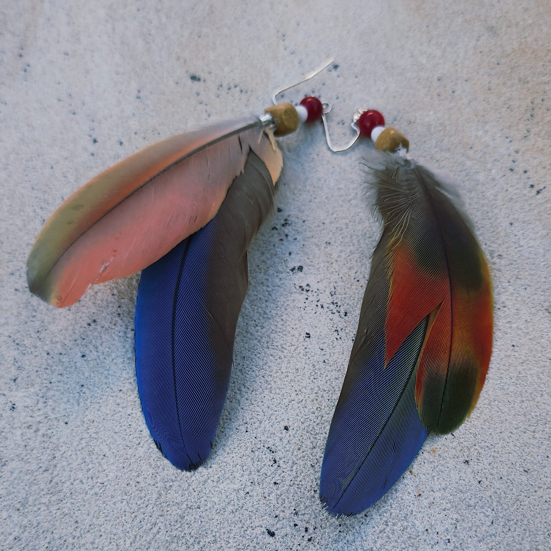 Handmade blue green feather earrings with white howlite, wood, and coral-colored beads, long coastal dangle earrings