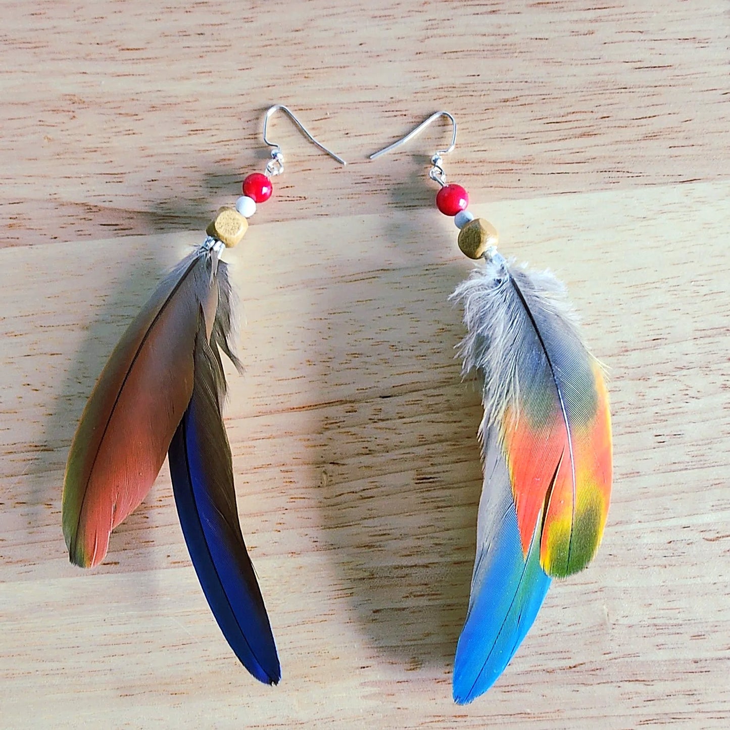 Handmade blue green feather earrings with white howlite, wood, and coral-colored beads, long coastal dangle earrings