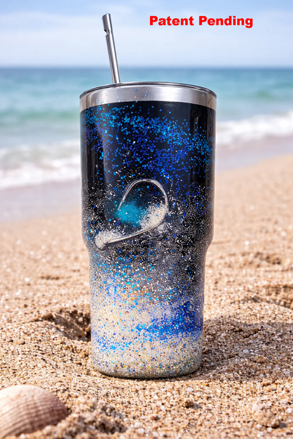 30oz black epoxy fishing hook tumbler with real sand and blue glitter on coastal beach background