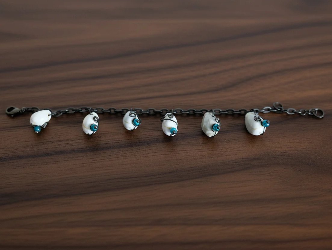 Close up of shell bracelet stretched out showing alternating green and blue beads on oxidized chain