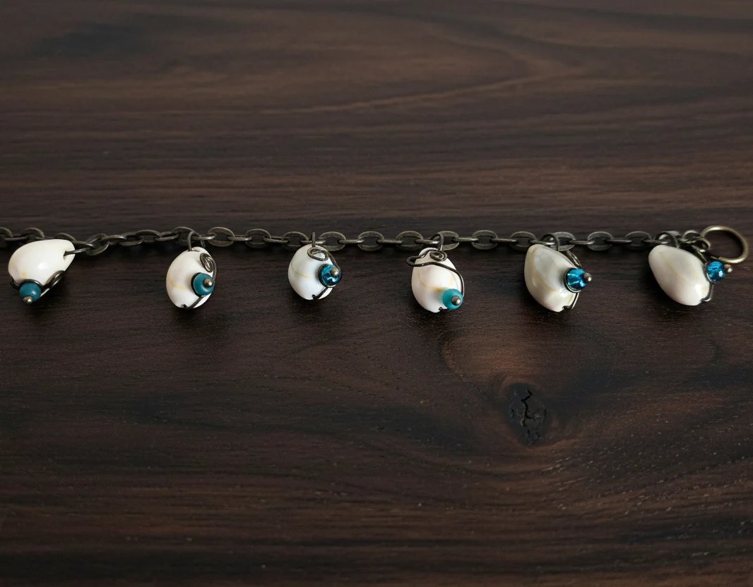 Handmade shell bracelet on dark wood background with green and blue beads and wire wrapped shells