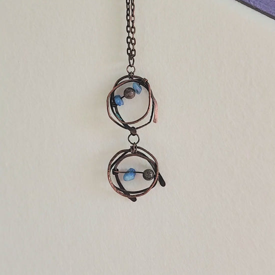 Close-up video of handmade copper wire-wrapped pendant necklace with brown jasper and blue abalorios gemstone chips