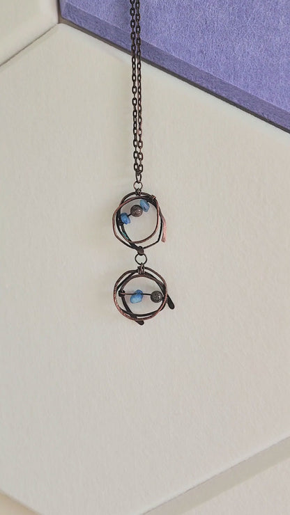 Close-up video of handmade copper wire-wrapped pendant necklace with brown jasper and blue abalorios gemstone chips