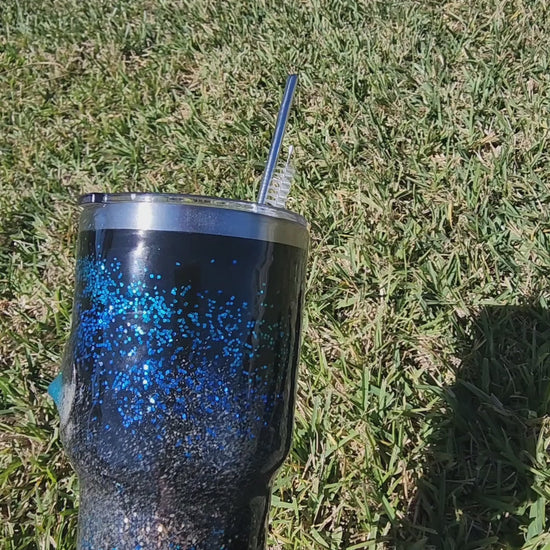 Saltwater Surge 30oz fishing hook tumbler with layered blue glitter and real sand epoxy design on beach