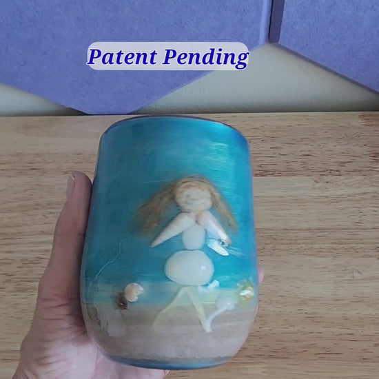 close view of a handmade shell people wine tumbler held in hand, real shells and glossy finish
