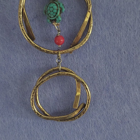 Video of handmade brass turtle pendant necklace showing hammered texture detail