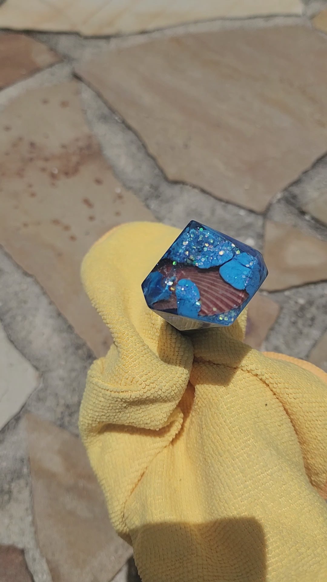 Handmade sapphire blue geometric resin wine stopper with embedded seashell, close-up
