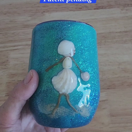 Video: hand holding a teal shell people wine tumbler with a white seashell figure