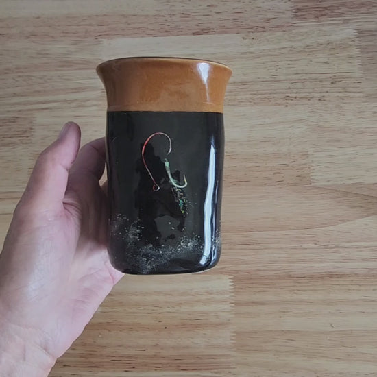 Video of hand holding a handmade Hook & Tumble black coffee mug to show its size and finish 