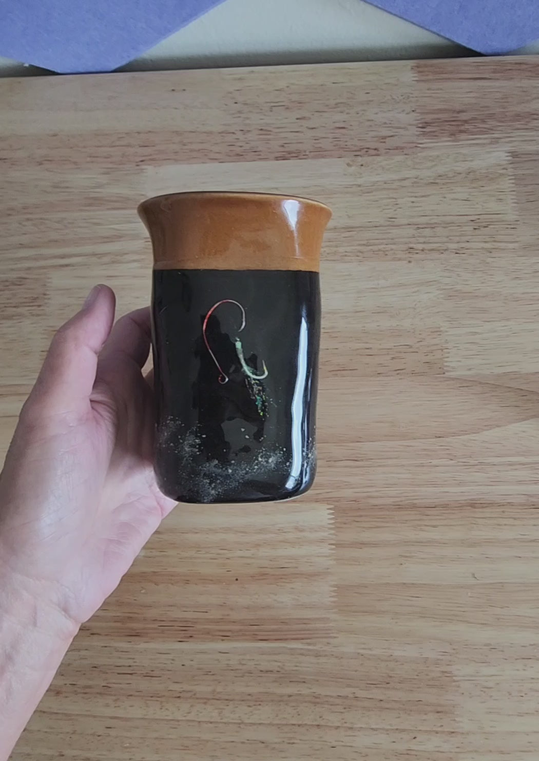 Video of hand holding a handmade Hook & Tumble black coffee mug to show its size and finish 