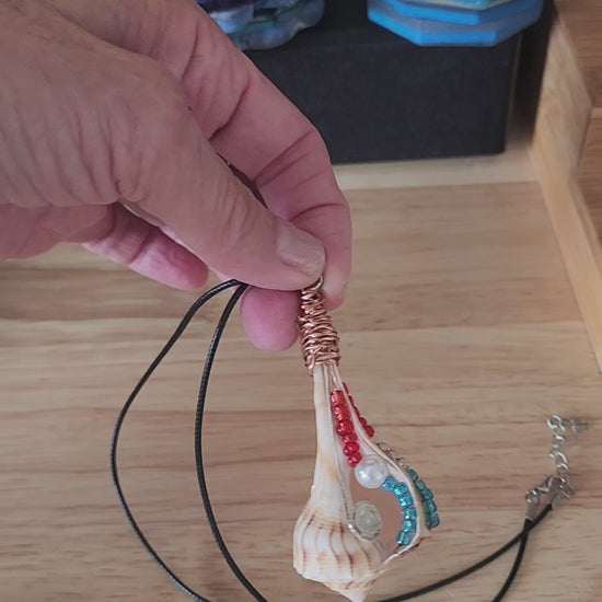 Lightning Whelk seashell pendant necklace video showing copper wire wrapped shell with red white blue beads and pearl