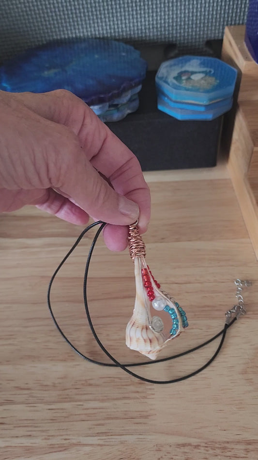 Lightning Whelk seashell pendant necklace video showing copper wire wrapped shell with red white blue beads and pearl