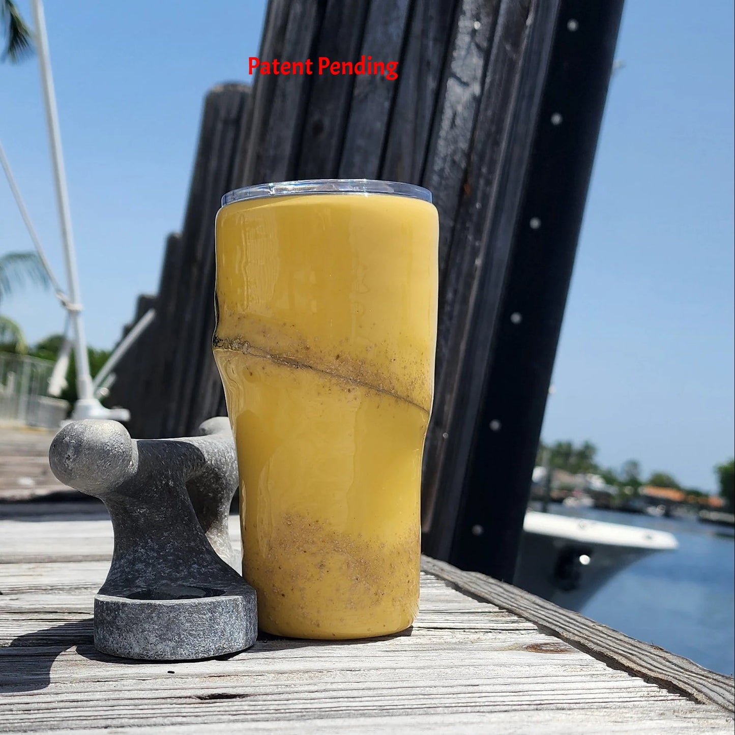 Golden Hour 20oz Hook & Tumble fishing tumbler right side view showing golden yellow with sand accent, dock and boat in background