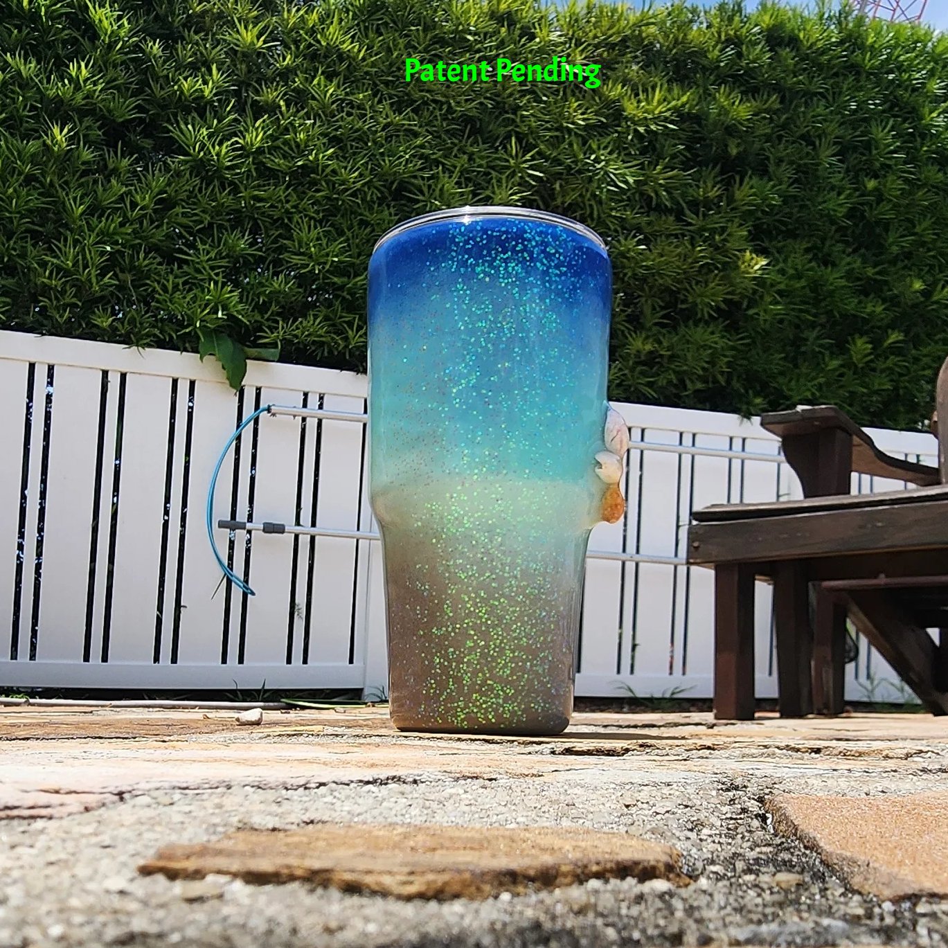 Left side view of Caribbean Glow Shell Glitter 30oz tumbler showing real seashells and holographic iridescent glitter color shift in natural light. Saltwater Sips™ by SoFlo Boho Boutique, Patent Pending.