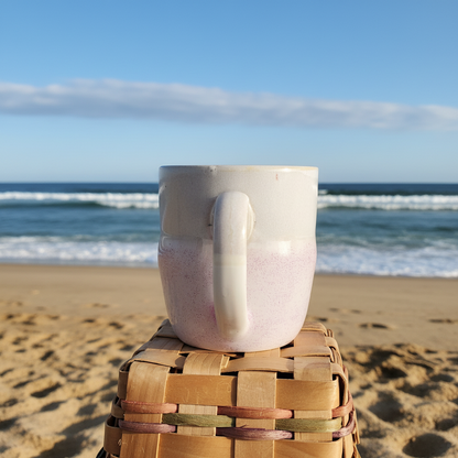 Coastal ceramic mug back view on sandy beach