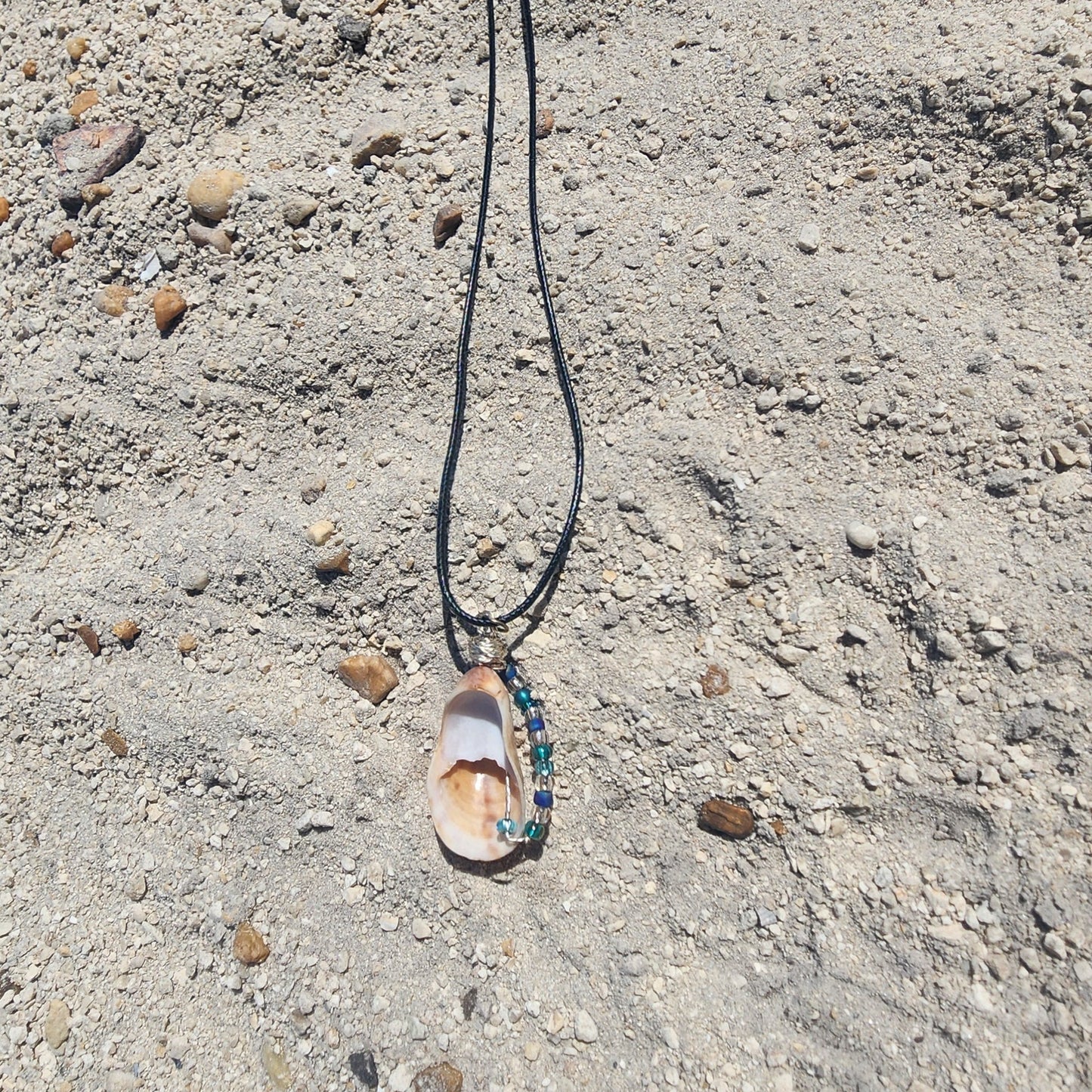 Handmade seashell pendant necklace backside with silver wire wrap and blue green beads