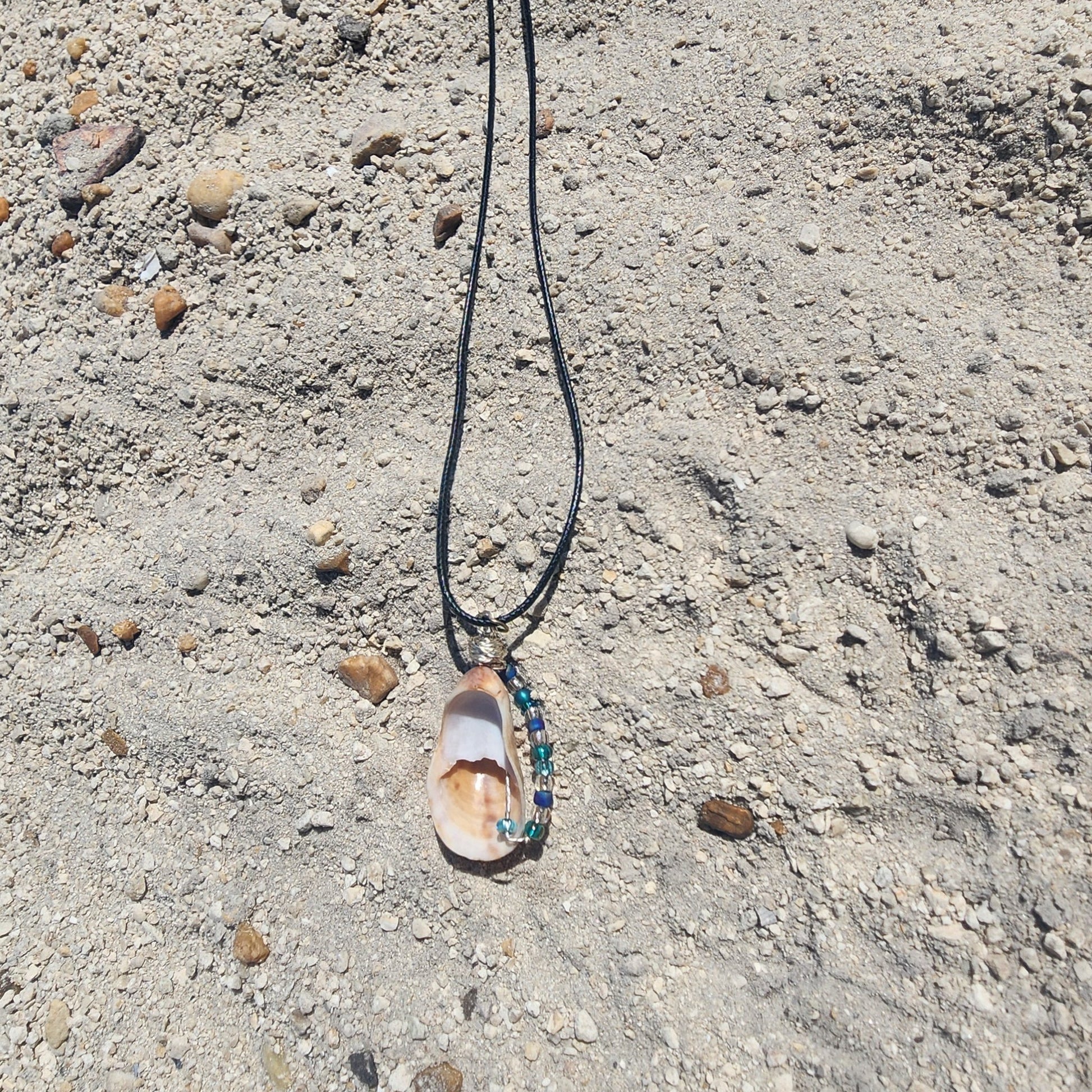 Handmade seashell pendant necklace backside with silver wire wrap and blue green beads