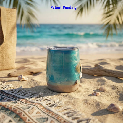 Handmade teal coastal wine tumbler with seashells on sand and driftwood