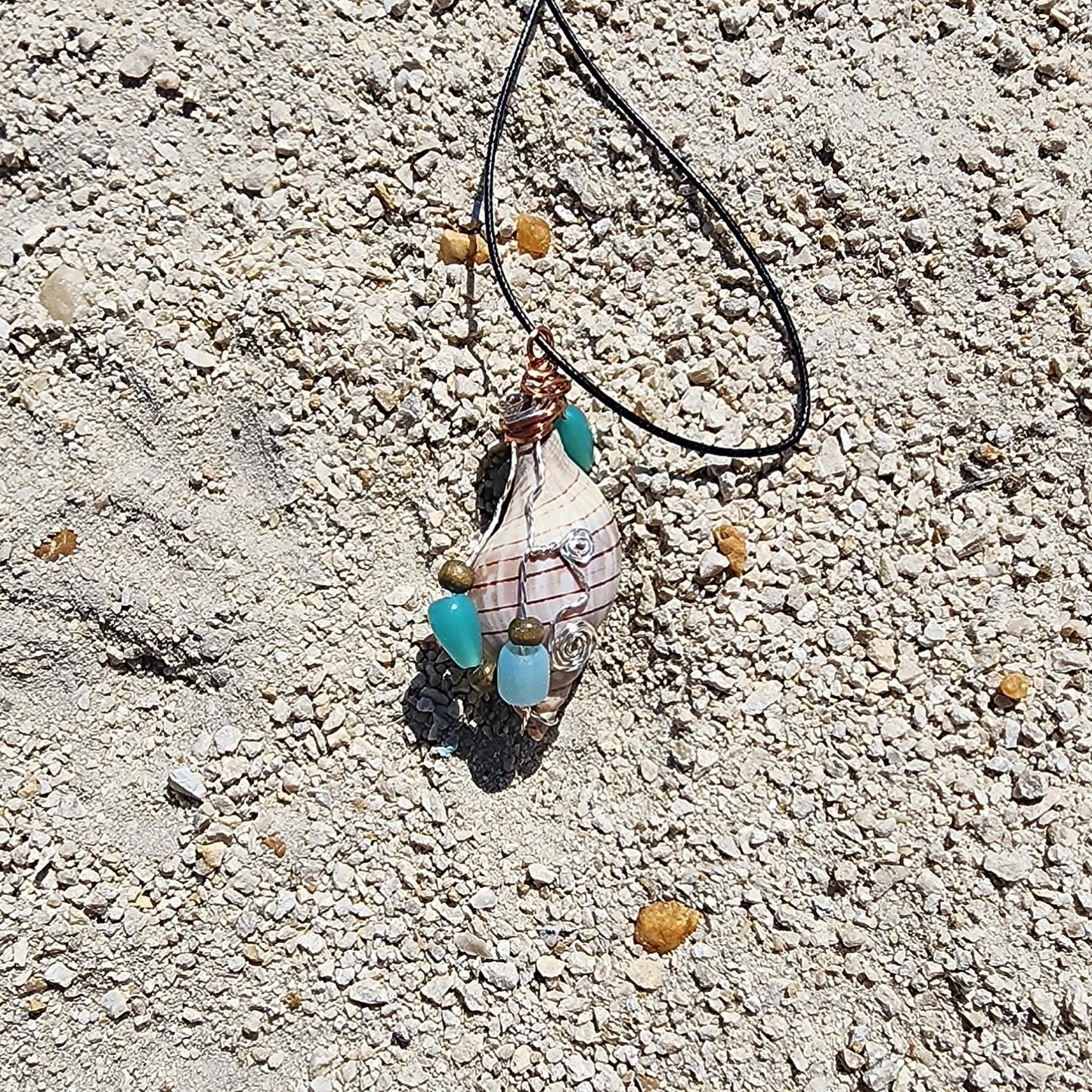 Handmade tulip shell pendant necklace with mixed metal wire wrap, turquoise beads, and wood accents on cord