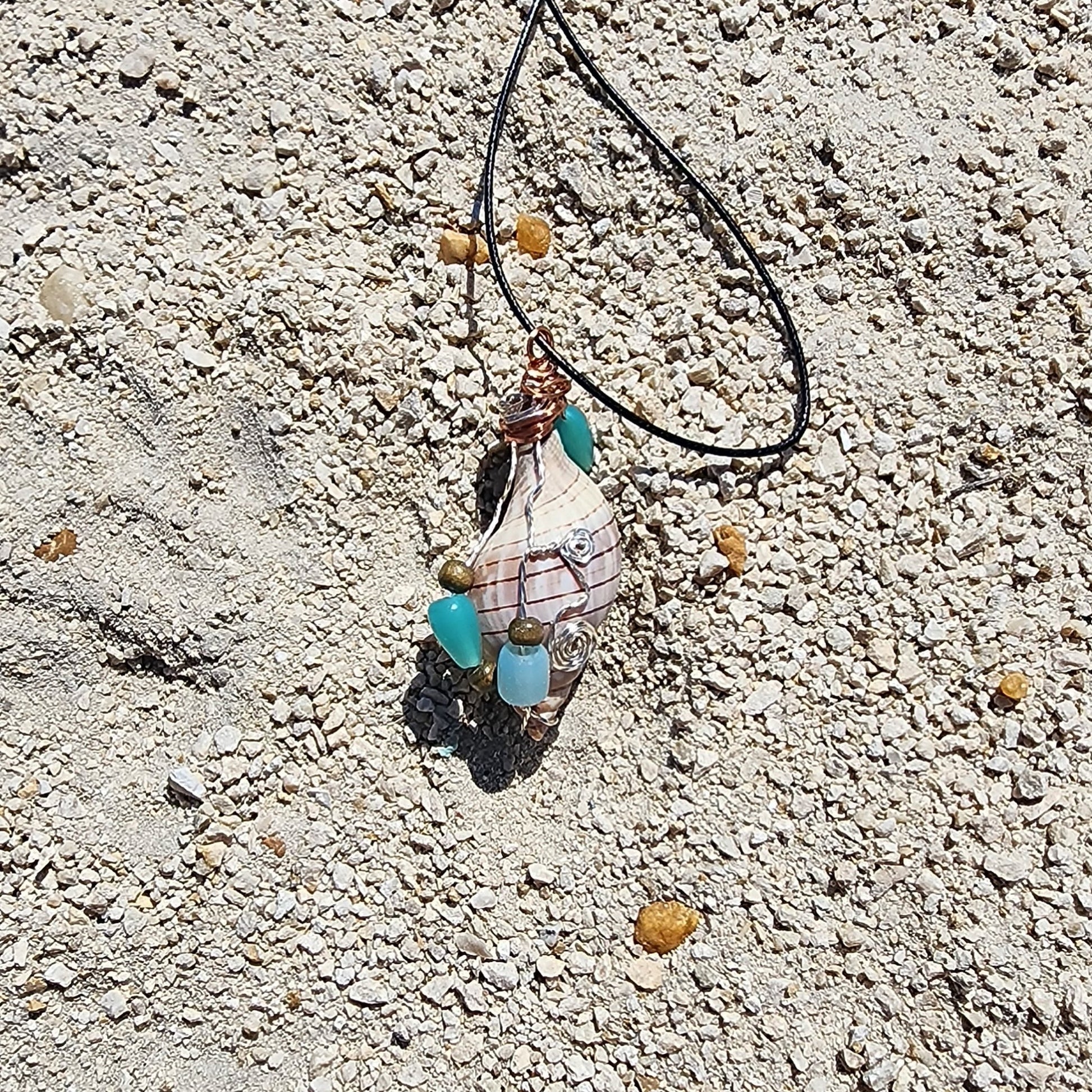 Handmade tulip shell pendant necklace with mixed metal wire wrap, turquoise beads, and wood accents on cord