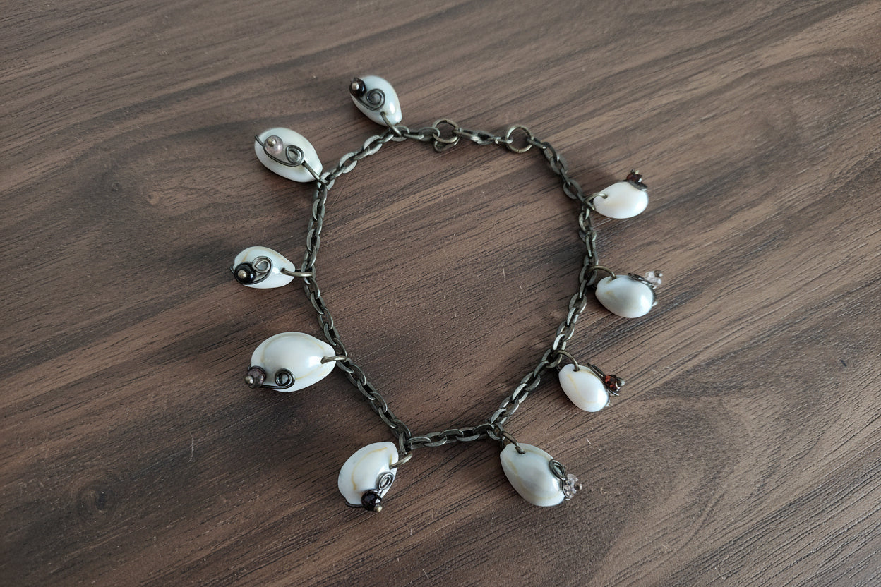 Handmade beach anklet bracelet with cowrie shells on wood background coastal boho jewelry