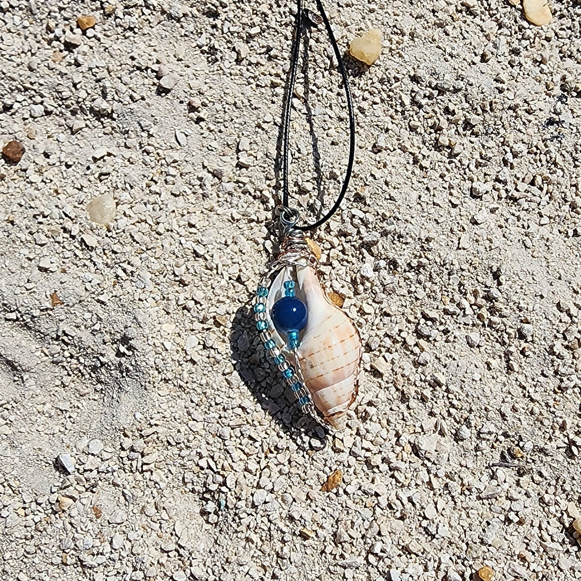 Handmade tulip shell pendant necklace with copper wire wrap, blue ceramic bead, and glass beads on cord