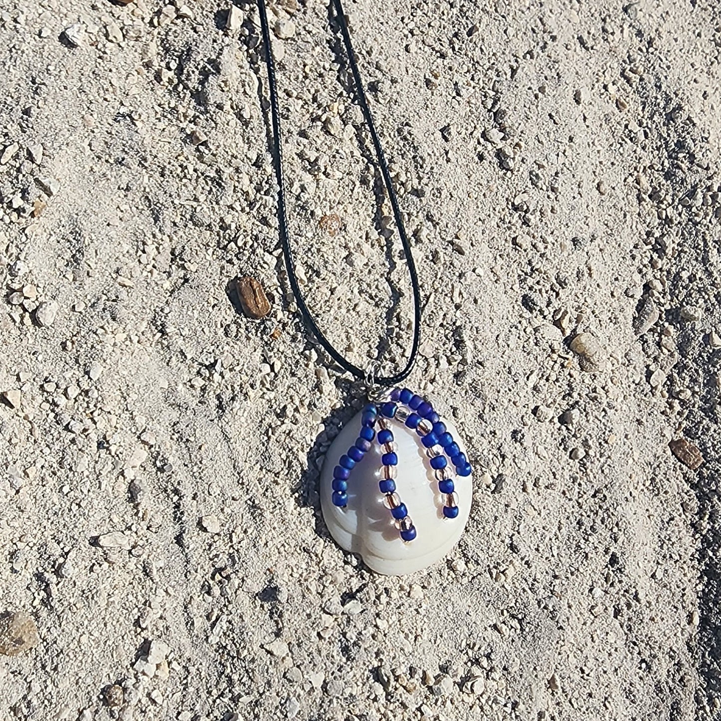 Handmade White Lucina shell pendant necklace with silver wire wrap and purple bead strands