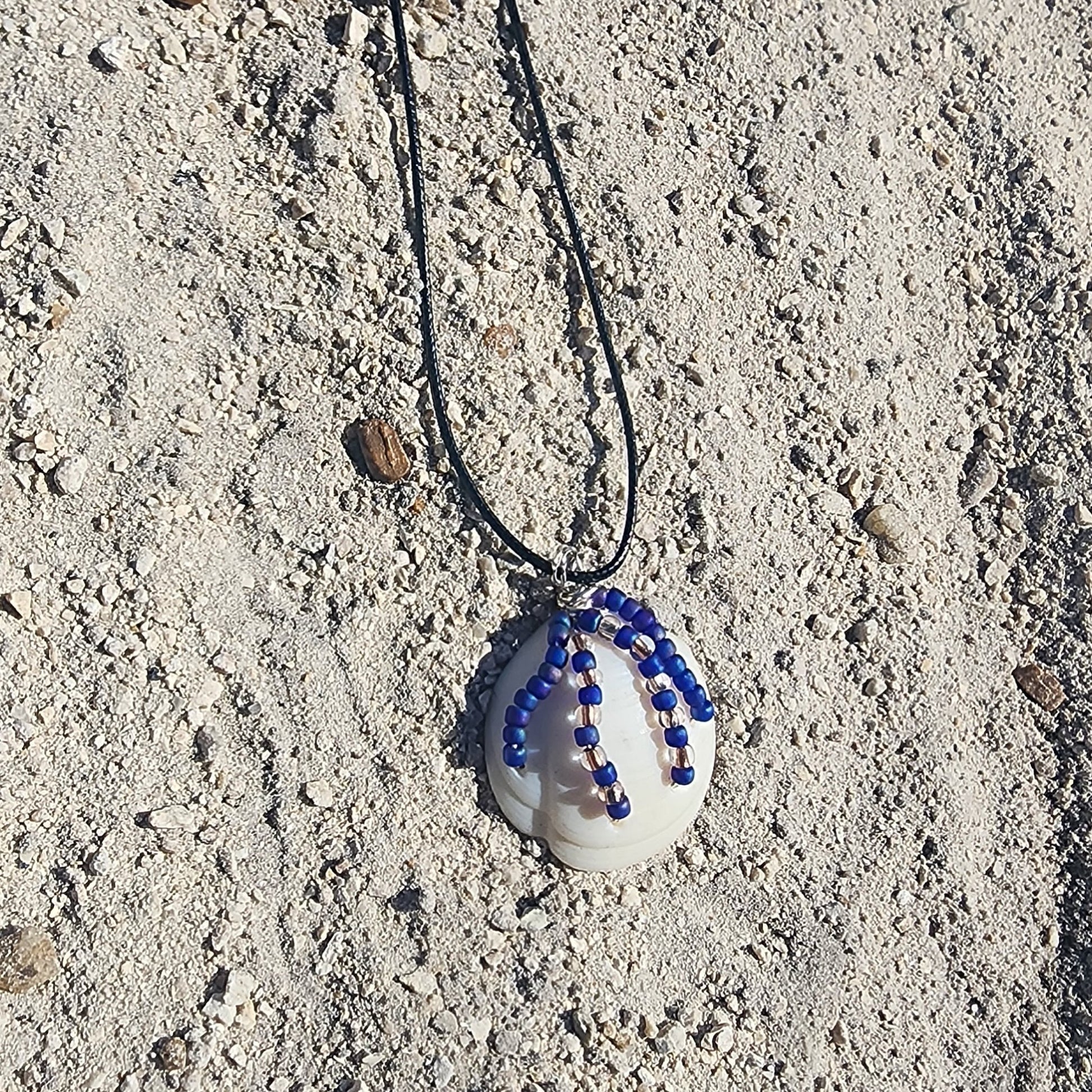 Handmade White Lucina shell pendant necklace with silver wire wrap and purple bead strands