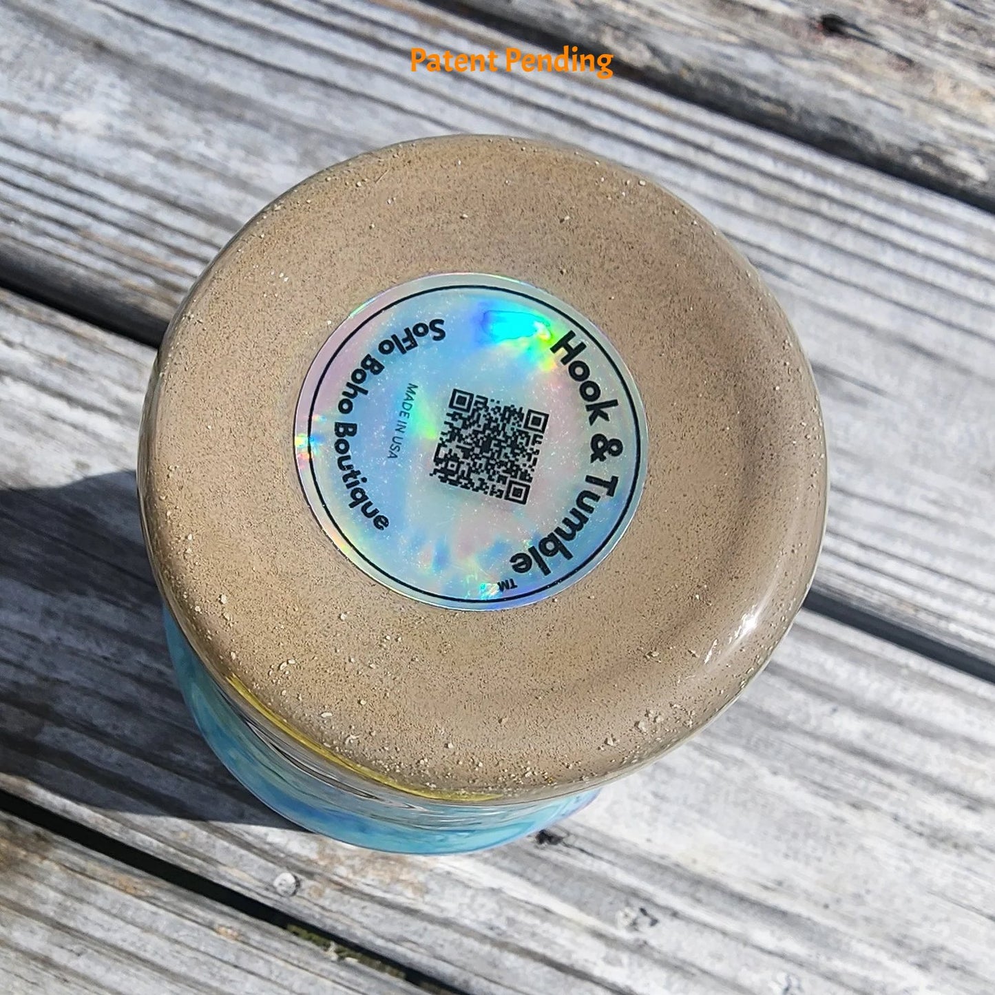 Bottom view of Crystal Shore Deep 30oz fishing tumbler on South Florida marina dock showing holographic Hook & Tumble™ brand label with QR code and SoFlo Boho Boutique branding. Made in USA, Patent Pending.