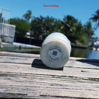 Base view of White Sands Hook & Tumble™ tumbler showing real fishing hooks and sand in clear epoxy resin