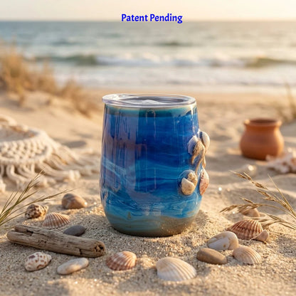 Blue 12oz insulated stainless steel wine tumbler with a seashell figure on beach