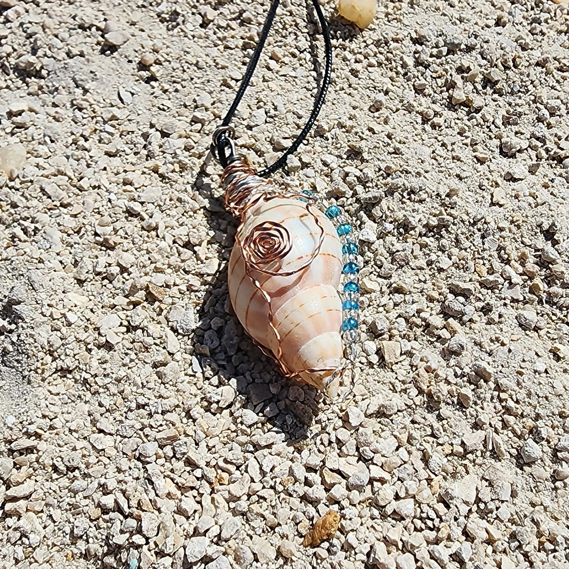 Handmade tulip shell pendant necklace with copper wire wrap, blue ceramic bead, and glass beads on cord