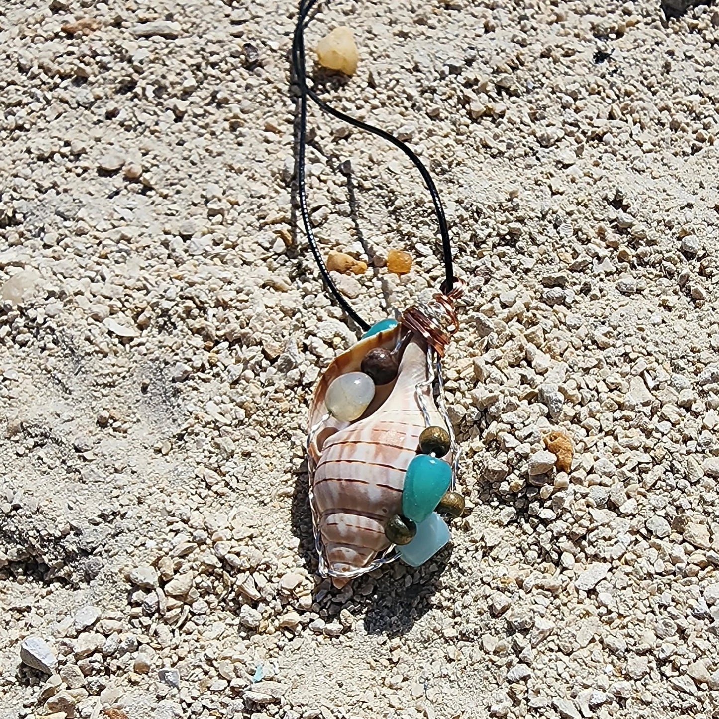 Handmade tulip shell pendant necklace with mixed metal wire wrap, turquoise beads, and wood accents on cord