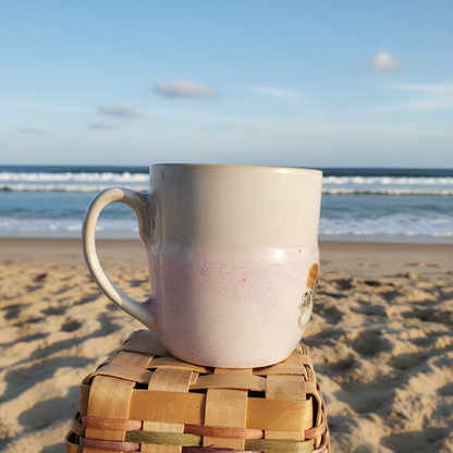 Saltwater Sips seashell mug with ocean waves in background