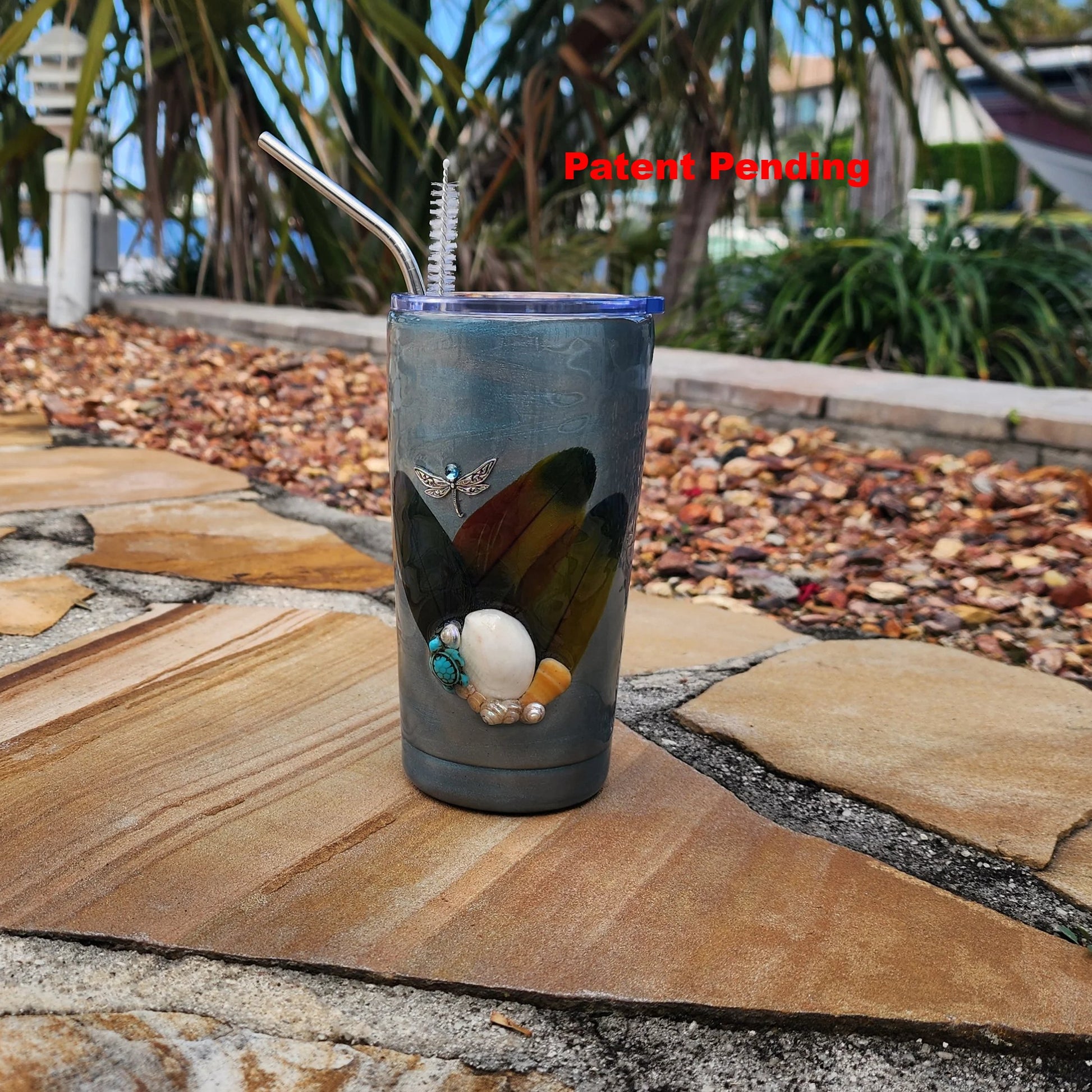 Close-up of real Florida seashells and feather accents on teal coastal tumbler