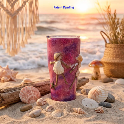 Pink and purple glitter insulated tumbler with real seashells on a sandy beach at sunset