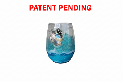 Decorative stemless wine  glass with seashells and blue and white design on a white background