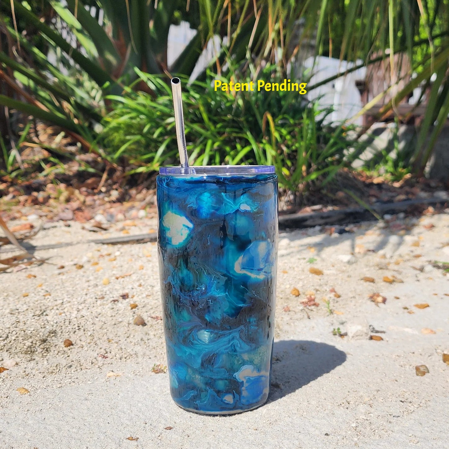 Hook & Tumble Blue Lagoon 20oz tumbler outdoor shot, navy teal and cobalt blue swirls over stainless steel