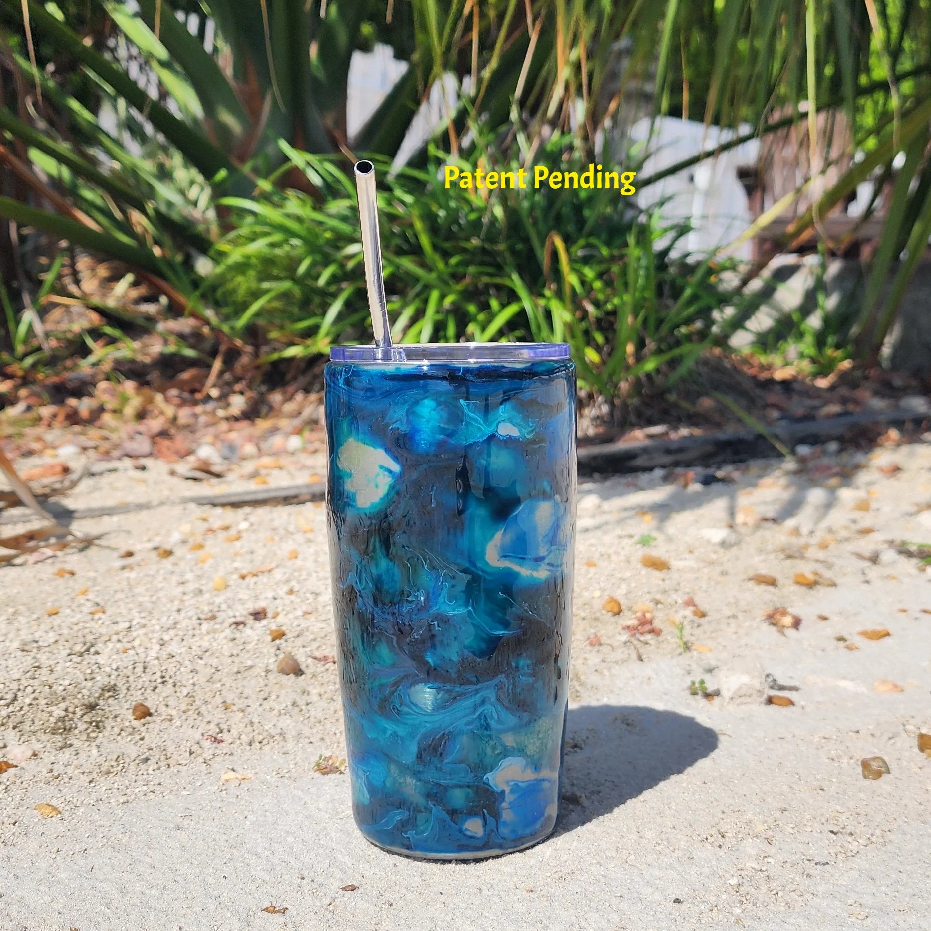 Hook & Tumble Blue Lagoon 20oz tumbler outdoor shot, navy teal and cobalt blue swirls over stainless steel