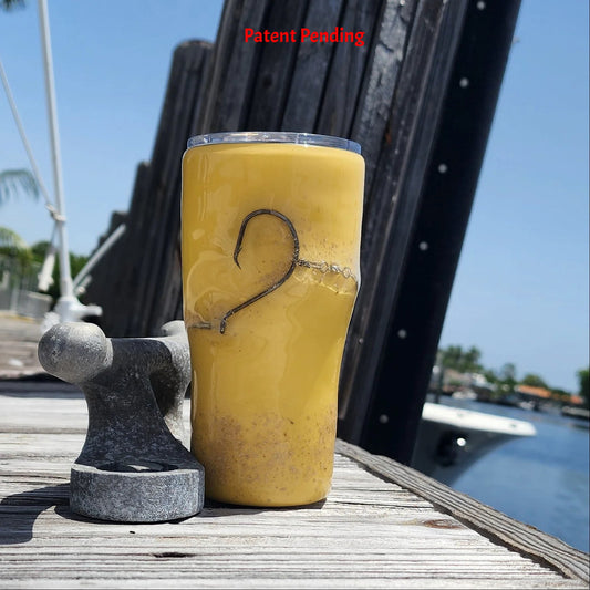 Golden Hour 20oz Hook & Tumble fishing tumbler front view showing authentic fishing hook and sand accent on golden yellow with dock and boat in background