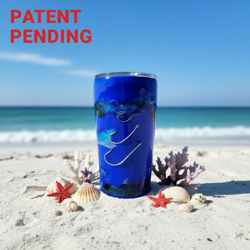 Blue tumbler with ocean design on a sandy beach with shells and coral