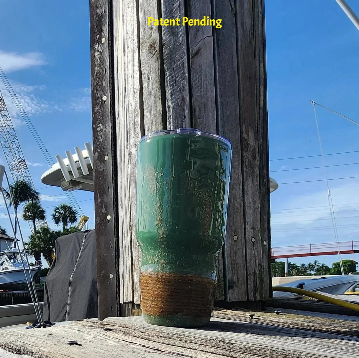 Marsh Tide 30oz Hook & Tumble Patent Pending fishing tumbler full view on marina dock with boats and palm trees showing marsh green finish and natural rope wrapped base