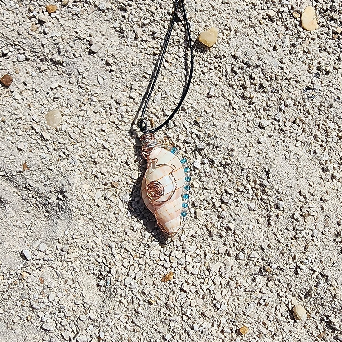 Handmade tulip shell pendant necklace with copper wire wrap, blue ceramic bead, and glass beads on cord